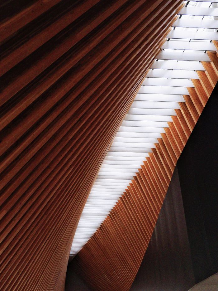 Abstract view of a modern architectural structure with wooden beams and skylight.